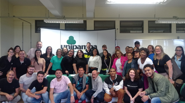 Comunidade Surda e professoras da educação básica de São Borja e colaboradores da Unipampa (Foto: Divulgação) Imagem em ambiente fechado contendo pessoas interagindo.