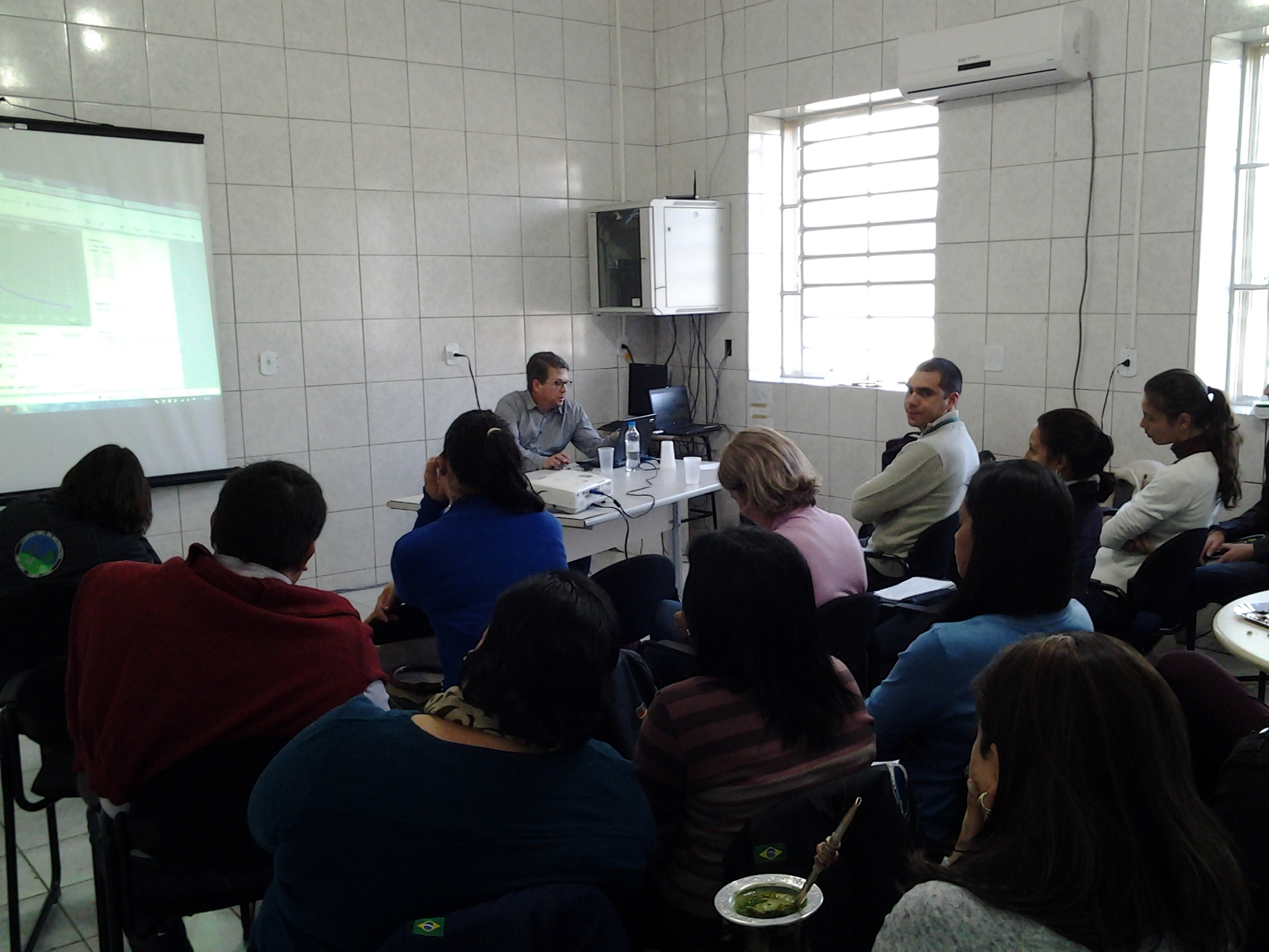 Grupo de docentes e discentes reunidos em sala de aula com o ministrante, o professor André Ferreira
