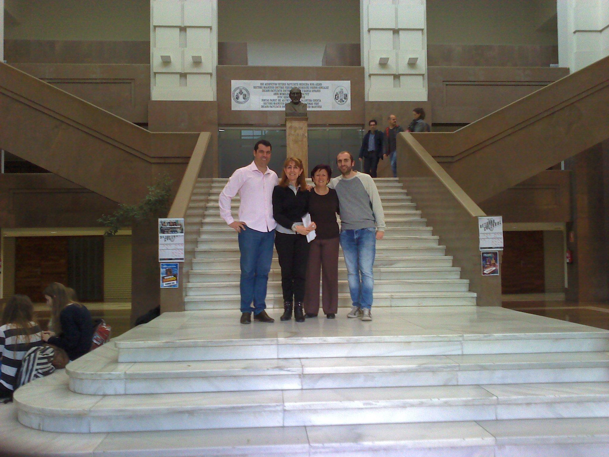quatro pessoas posam para foto em frente a escadaria.