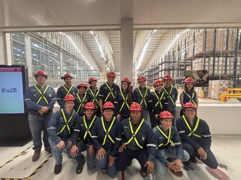 Participantes da visita técnica à unidade da Coca-Cola, em Santa Cruz de la Sierra. (Foto: acervo da mobilidade) Foto em grupo de muitas pessoas em uma sala com vestimentas de epi