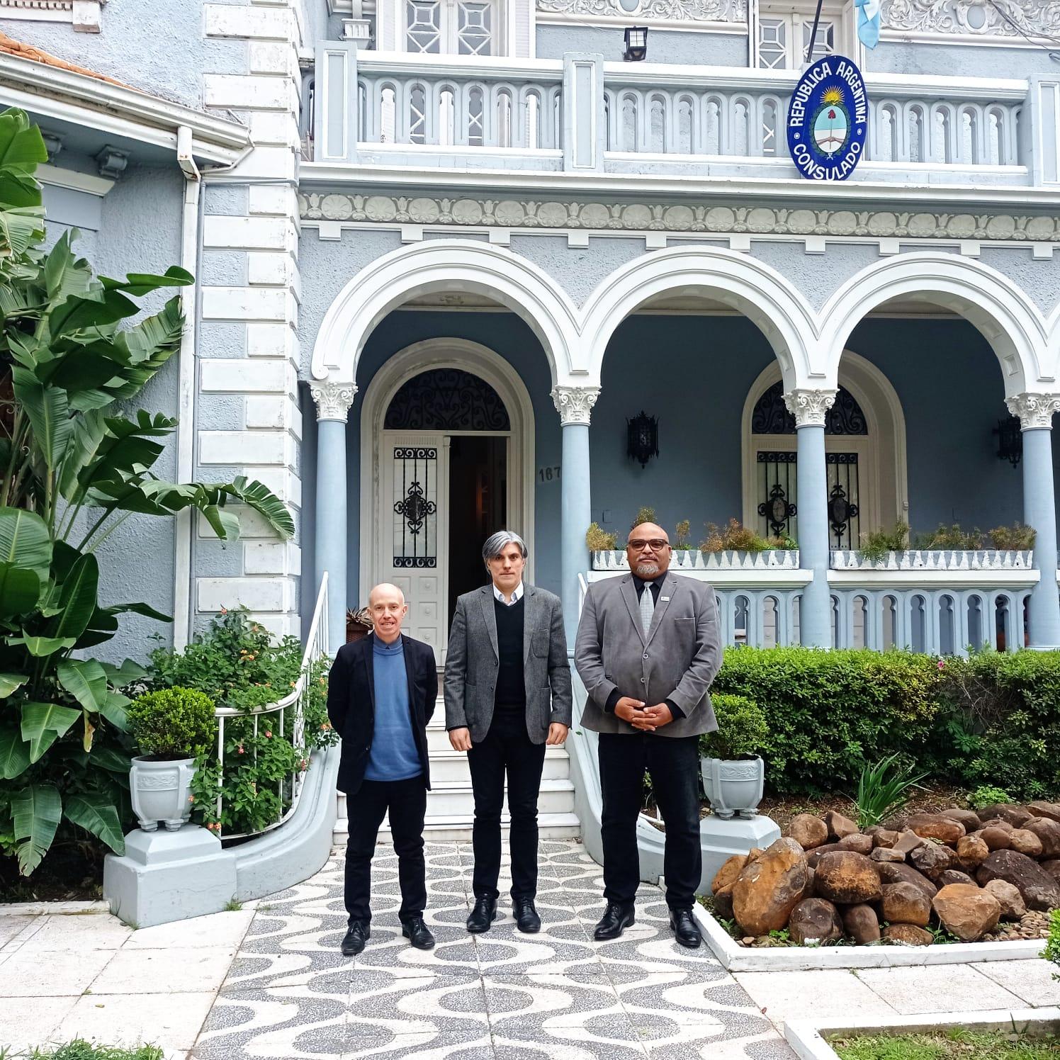 Vice-reitor, cônsul e reitor posam para foto em frente ao consulado da Argentina em Uruguaiana.